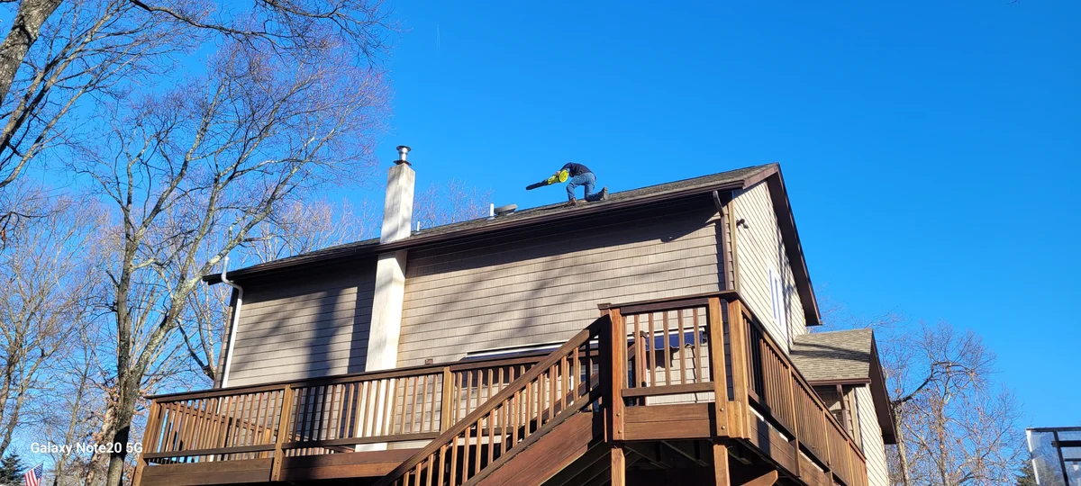 Two-story house with large multilevel wood deck cleaned during winter, deep blue sky